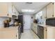 Traditional kitchen with white cabinets, stainless steel appliances, and a skylight at 9100 Whitman Ln, Port Richey, FL 34668