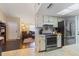 Open-concept kitchen offering views to the living and entry, stainless steel appliances, white cabinets and light countertops at 9100 Whitman Ln, Port Richey, FL 34668