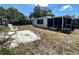 A cozy backyard features white chairs on a stone area and a screen porch at 9104 Lido Ln, Port Richey, FL 34668
