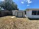 A white outdoor shed sits on a backyard lot that is surrounded by a wooden fence at 9104 Lido Ln, Port Richey, FL 34668