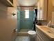 Compact bathroom with a tiled shower, sink, and toilet, offering essential amenities at 9104 Lido Ln, Port Richey, FL 34668