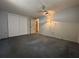 Spacious bedroom with a ceiling fan, carpet flooring, and a large double-door closet for ample storage at 9104 Lido Ln, Port Richey, FL 34668