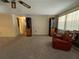 Living room with plush carpet, large windows, and a comfortable red chair offers a relaxing space at 9104 Lido Ln, Port Richey, FL 34668