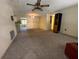 Spacious living room featuring carpet and a ceiling fan, providing a cozy and comfortable living space at 9104 Lido Ln, Port Richey, FL 34668