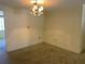 Open living room with carpeted floors and chandelier lighting at 9104 Lido Ln, Port Richey, FL 34668