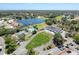 Expansive aerial view of a community featuring a lake, pool, tennis courts and clubhouse at 9237 Penelope Dr, Weeki Wachee, FL 34613