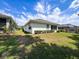 Expansive backyard with lush lawn, showcasing the home's exterior, and screened in patio in background at 9237 Penelope Dr, Weeki Wachee, FL 34613