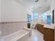 Bright bathroom featuring a large bathtub, double sinks, lots of cabinet space and granite counters at 9237 Penelope Dr, Weeki Wachee, FL 34613