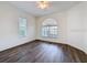 Bright bedroom with hard wood floors, a ceiling fan, and two windows with a backyard view at 9237 Penelope Dr, Weeki Wachee, FL 34613