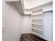 Walk-in closet features custom white shelving and a hanging rack for optimal storage at 9237 Penelope Dr, Weeki Wachee, FL 34613
