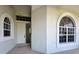 Inviting front entryway with arched windows and a white front door at 9237 Penelope Dr, Weeki Wachee, FL 34613