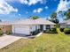 Charming single-story home with a well-maintained lawn, mature landscaping, and an attached two-car garage at 9237 Penelope Dr, Weeki Wachee, FL 34613