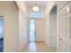Bright foyer features tiled flooring, white front door, and transom window allowing natural light to fill the entry at 9237 Penelope Dr, Weeki Wachee, FL 34613