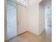 Bright foyer with tile flooring, white front door with transom window, and view of cabinets through arched opening at 9237 Penelope Dr, Weeki Wachee, FL 34613