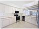 The updated kitchen features white cabinets, stainless steel appliances, and an open layout perfect for cooking at 9237 Penelope Dr, Weeki Wachee, FL 34613