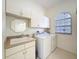 The laundry room has a utility sink, storage cabinets, and a window for natural light at 9237 Penelope Dr, Weeki Wachee, FL 34613