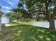 A serene view of the backyard overlooking the pond, shaded by a mature tree at 9336 Santa Monica Way, New Port Richey, FL 34655
