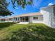 Lush backyard features well-maintained green lawn, a screened lanai and white exterior at 9336 Santa Monica Way, New Port Richey, FL 34655