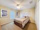 Comfortable bedroom with ceiling fan and plush neutral carpet at 9336 Santa Monica Way, New Port Richey, FL 34655