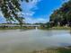 A picturesque pond view with a fountain and lush surroundings under a blue sky at 9336 Santa Monica Way, New Port Richey, FL 34655