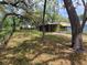Exterior view showcasing the side yard and mature trees and carport at 9441 Teak St, New Port Richey, FL 34654