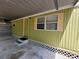 Exterior view of the home, showcasing an attached carport with security signage at 9441 Teak St, New Port Richey, FL 34654