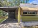 Exterior of a green home featuring a carport and well-maintained landscaping at 9441 Teak St, New Port Richey, FL 34654