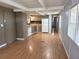 Open kitchen with white appliances, grey cabinets, and hardwood floors at 9441 Teak St, New Port Richey, FL 34654