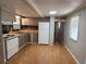 Galley kitchen featuring gray cabinets, tile backsplash and light wood colored flooring at 9441 Teak St, New Port Richey, FL 34654