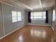 Light-filled living room with hardwood floors and ample window space at 9441 Teak St, New Port Richey, FL 34654