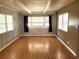 Bright living room with light wood flooring, paneled walls, and natural light from multiple windows at 9441 Teak St, New Port Richey, FL 34654