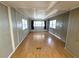 Bright living room with light wood flooring, paneled walls, and natural light from multiple windows at 9441 Teak St, New Port Richey, FL 34654