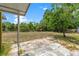Spacious backyard offering mature trees, partial fence, and a concrete patio area at 9640 Northcliffe Blvd, Spring Hill, FL 34608