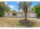 Charming single-story home featuring a well-kept lawn and a mature palm tree in the front yard at 9640 Northcliffe Blvd, Spring Hill, FL 34608