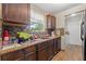 Kitchen featuring dark wood cabinets, tile backsplash, and stainless steel appliances adjacent laundry room at 9640 Northcliffe Blvd, Spring Hill, FL 34608