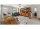 Inviting living room featuring tile flooring, a ceiling fan, and large windows allowing natural light at 9640 Northcliffe Blvd, Spring Hill, FL 34608