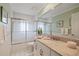Bathroom with a granite countertop, white cabinets, a large mirror, and a sliding glass door shower at 9652 Oakwood Hills Ct, New Port Richey, FL 34655