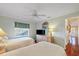 Bright bedroom featuring hardwood floors, two twin beds, a ceiling fan, and a window with shade at 9652 Oakwood Hills Ct, New Port Richey, FL 34655