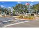 Community entrance sign for Timber Greens with mature landscaping and a charming guard house at 9652 Oakwood Hills Ct, New Port Richey, FL 34655