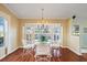 Bright dining area featuring wood floors, chandelier, and a large window offering plenty of natural light at 9652 Oakwood Hills Ct, New Port Richey, FL 34655