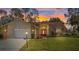 Charming single-story home at sunset with a well-maintained lawn, two car garage, and stone accents at 9652 Oakwood Hills Ct, New Port Richey, FL 34655