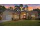 Scenic front exterior of home at sunset, featuring stone accents and well-maintained landscaping at 9652 Oakwood Hills Ct, New Port Richey, FL 34655