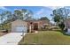 Charming single-story home with well-manicured lawn, brick accents, and a welcoming red front door at 9652 Oakwood Hills Ct, New Port Richey, FL 34655
