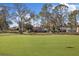 Scenic view of the golf course, with blue flag, surrounded by mature trees and homes at 9652 Oakwood Hills Ct, New Port Richey, FL 34655