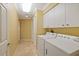 Laundry room featuring a washer, dryer, white cabinets, and a neutral tile floor at 9652 Oakwood Hills Ct, New Port Richey, FL 34655