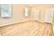 Neutral bedroom featuring wood floors, two windows, white trim and baseboards, and a closet at 11041 Paradise Point Way, New Port Richey, FL 34654