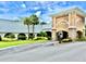An inviting clubhouse entrance with lush landscaping, enhanced by vibrant green grass and mature palm trees at 11041 Paradise Point Way, New Port Richey, FL 34654