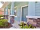Charming front porch with decorative stone pillars and a welcoming blue front door at 11041 Paradise Point Way, New Port Richey, FL 34654