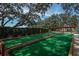 Well-maintained bocce ball court surrounded by lush greenery and mature trees for outdoor enjoyment at 11241 Dollar Lake Dr # 5, Port Richey, FL 34668