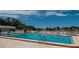 The refreshing community pool features ample seating, lush landscaping, and a beautiful open sky at 11241 Dollar Lake Dr # 5, Port Richey, FL 34668